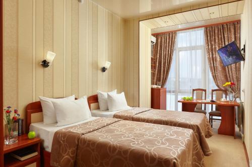 a hotel room with two beds and a window at Russky Capital Hotel in Nizhny Novgorod