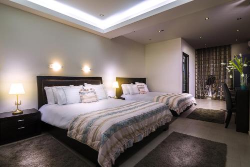 a hotel room with two beds and two lamps at Pansion Zafeiriou in Kastoria