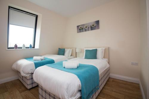 two twin beds in a room with a window at Castle Point Apartments Southampton Premier Lodge in Southampton
