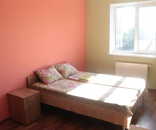 a small bed in a room with a window at Friendly House in Vyshneve