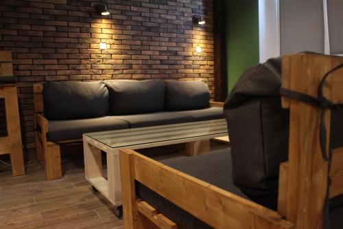 a living room with a couch and a brick wall at Friendly House in Vyshneve