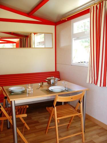 a dining room with a table and two chairs at Parque de Campismo Orbitur Montargil in Montargil