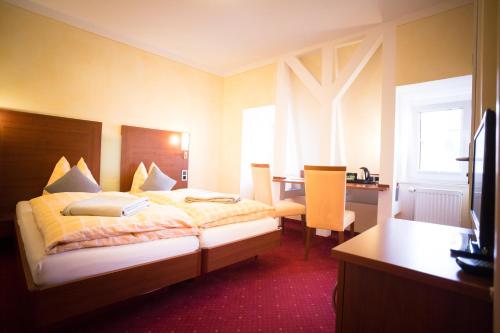 a hotel room with a bed and a desk at Hotel-Pension Berger in Heidelberg