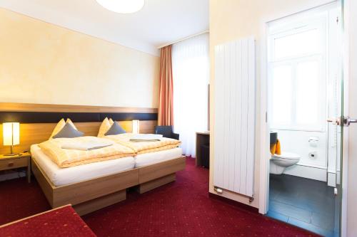 a hotel room with a bed and a bathroom at Hotel-Pension Berger in Heidelberg