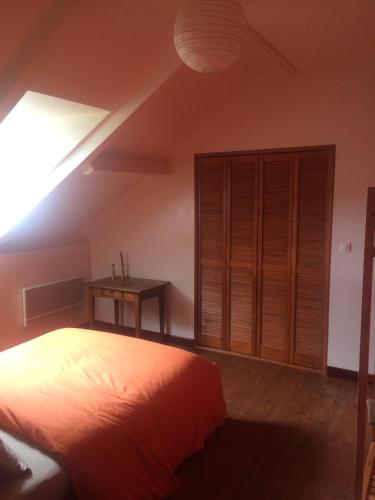 - une chambre mansardée avec un lit et une table dans l'établissement B&B Les Quatre Vents, à Montpon-Ménestérol