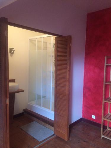 La salle de bains est pourvue d'une porte en verre et d'un lavabo. dans l'établissement B&B Les Quatre Vents, à Montpon-Ménestérol