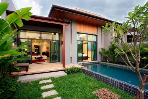 una casa con piscina frente a ella en Two Villas Holiday Phuket: Onyx Style Nai Harn Beach, en Nai Harn Beach