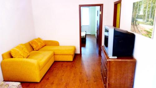 ニジネカムスクにあるАпартаменты на Тукая 32のリビングルーム(黄色のソファ、テレビ付)