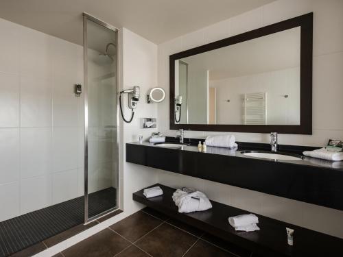 a bathroom with a sink and a mirror at Mercure Lyon Genas Eurexpo in Genas