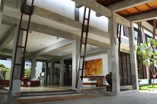 a lobby of a building with large glass windows at Goldi Sands Hotel in Negombo