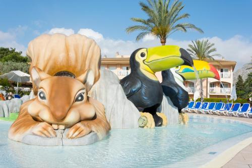 a statue of a dog and a bird in a pool at Mar Hotels Playa Mar & Spa in Port de Pollensa