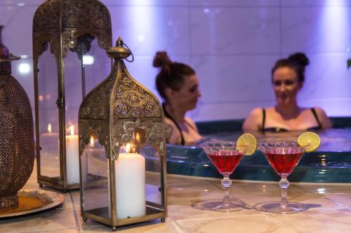 a woman in a bath tub with cocktails and candles at Best Western Hotel Gamla Teatern in Östersund