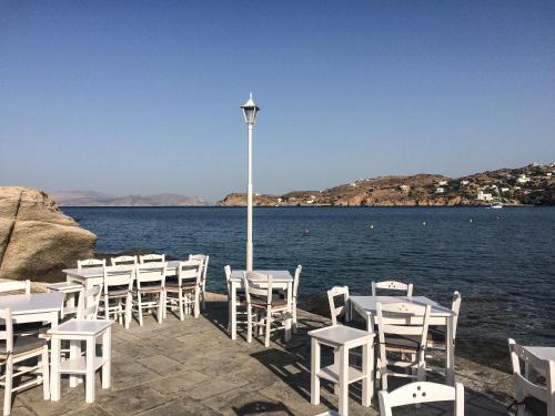 a row of tables and chairs on the water at Psili Ammos in Mylopotas