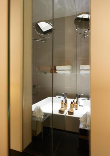 une salle de bain avec un lavabo et une douche en verre dans l'établissement Mercure Villefranche-sur-Saône, à Villefranche-sur-Saône