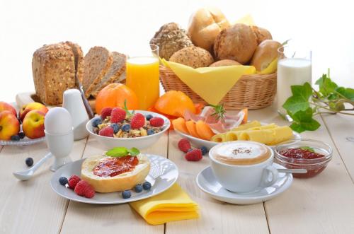 a table with a breakfast of fruit and coffee and bread at MBA modern beach apartments in Omiš