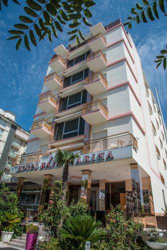 a tall white building with a sign on it at Hotel Baia Marina in Cattolica