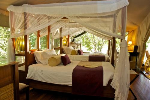 een slaapkamer met 2 bedden en een baldakijn bij Mara Intrepids Tented Camp in Talek