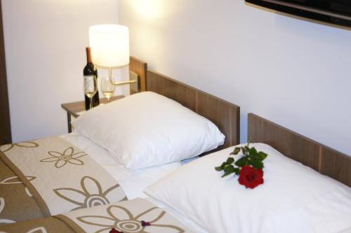 two beds with white pillows and a bottle of wine at Kalinowy Sen in Warsaw