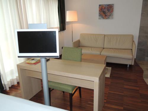 ein Wohnzimmer mit einem Schreibtisch und einem TV auf dem Tisch in der Unterkunft Cascina Scova Resort in Pavia