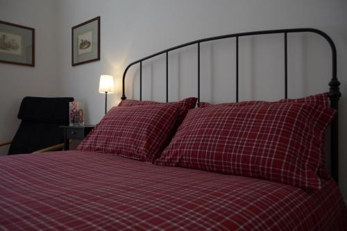 - un lit avec des draps et des oreillers en damier rouge dans l'établissement Il Limone A San Pietro, à Rome