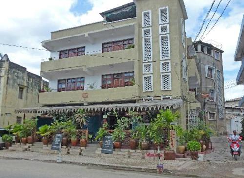 a building with potted plants in front of it at Zenji Hotel in Zanzibar City