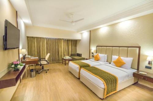 a hotel room with a large bed and a desk at Hotel Madhuban in Dehradun