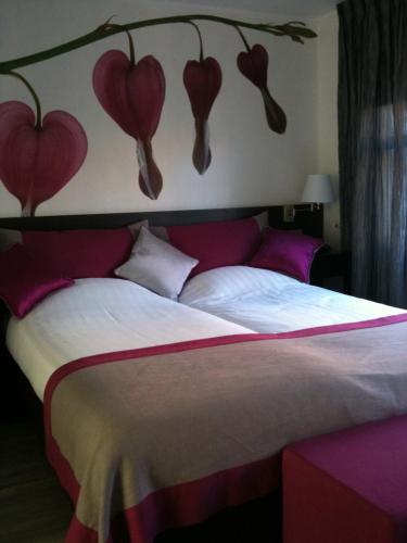 a bed with a headboard with hearts on the wall at In den Verdwaalde Koogel in Heusden