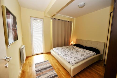 une petite chambre avec un lit et une fenêtre dans l'établissement Exclusive Apartments, à Skopje