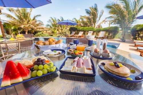 een tafel met veel eten erop bij BobZ Boutique Resort in Barra Grande