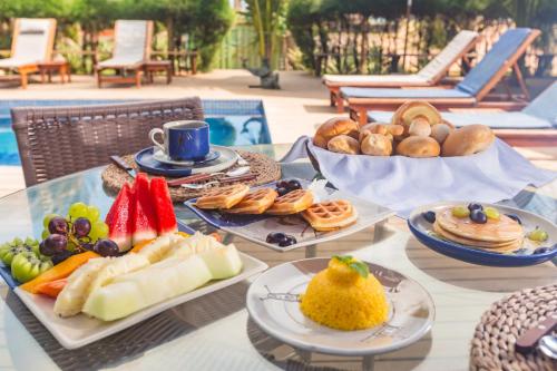 a table with plates of food on top at BobZ Boutique Resort in Barra Grande