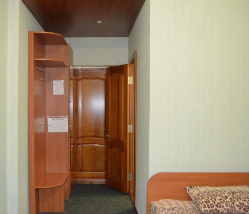 1 dormitorio con armario, cama y puerta en Sfinks, en Zaporozhye