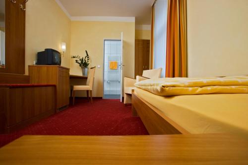 a hotel room with two beds and a television at Hotel-Pension Berger in Heidelberg
