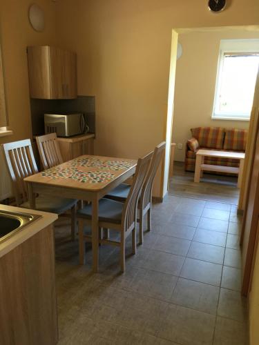 a kitchen and dining room with a table and chairs at PENZION HNAČOV in Zavlekov