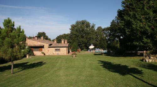 un gran patio con una casa de ladrillo y árboles en Casa Grazia, en Gambassi Terme