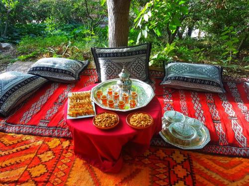 a table with bowls of food on a red blanket at Atlas Imoula in Imlil