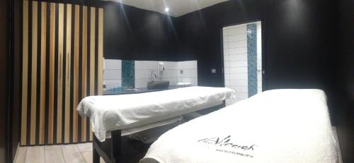 two beds in a room with black walls at Logis Hôtel et Spa Chez Camillou in Aumont-Aubrac