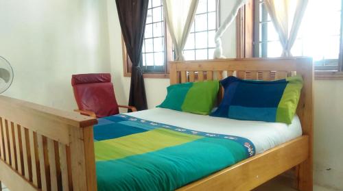 a bedroom with a wooden bed with colorful pillows at Egg Botanical View in Entebbe