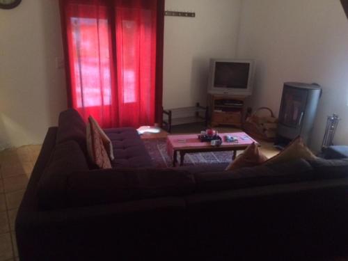 a living room with a couch and a tv at Ferme Dowena in Morillon
