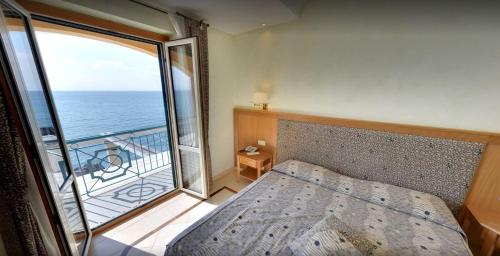 a bedroom with a bed and a view of the ocean at Hotel Ristorante La Lampara in Gizzeria