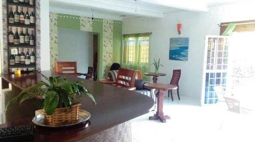 Habitación con bar con sillas y mesa. en Egg Botanical View en Entebbe