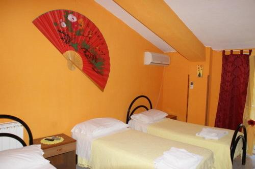 una camera con due letti e un ombrello rosso sul muro di La Conca D'oro ad Altomonte