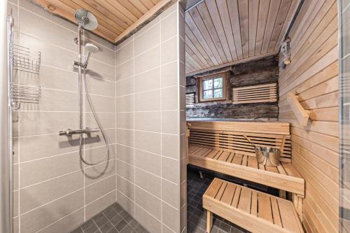 una sauna con ducha y bancos en una habitación en UnelmaKelo en Ruka