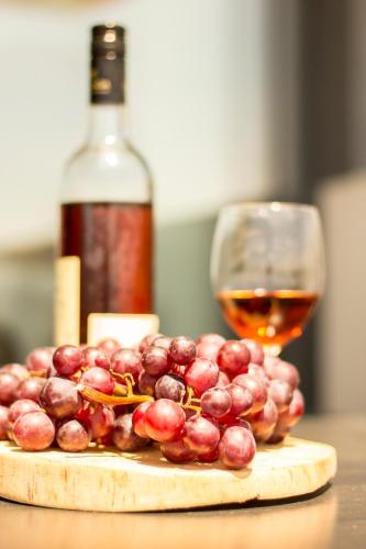 a glass of wine and a bunch of grapes on a table at Carina Villas in Lourinhã