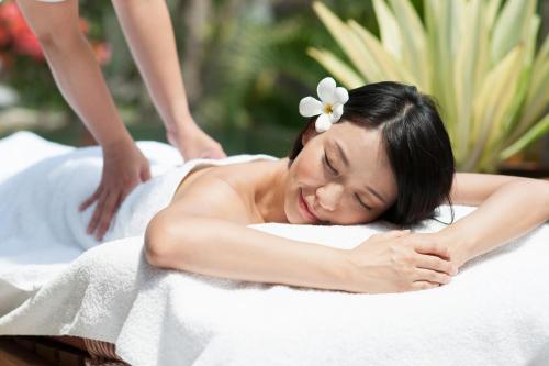 a woman in a bath tub with a flower on her head at Holly Camp Airstream Villa Amami in Amami