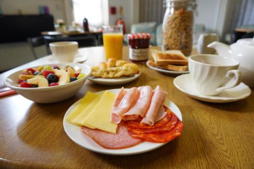 a wooden table with plates of food on it at Greyfriars Lodge Canterbury in Canterbury