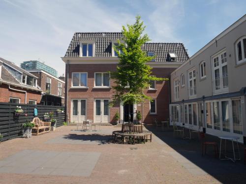 a building with a tree in the middle of a courtyard at Stayci Serviced Apartments Central Station in The Hague