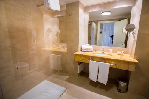 a bathroom with a sink and a shower and a mirror at Cefalù Sea Palace in Cefalù