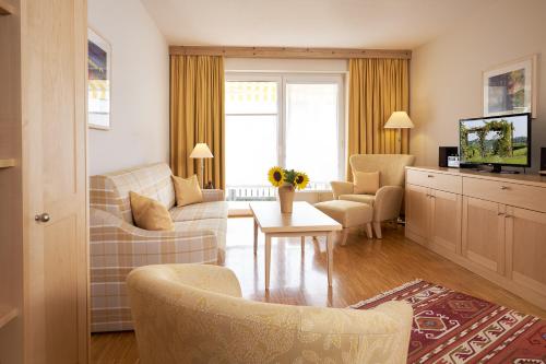a living room with a couch and chairs and a tv at Flair Hotel Schwanen in Bad Bellingen