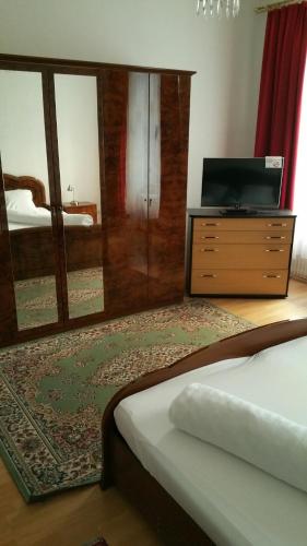 a bedroom with a bed and a dresser with a television at Appartement Hotel Marien-Hof in Vienna