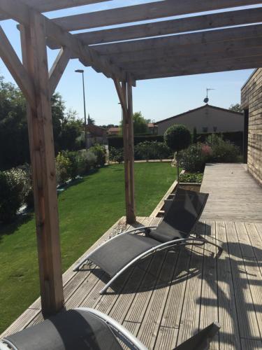 a wooden deck with a wooden pergola at Chambres d'hotes ASAM in Lherm